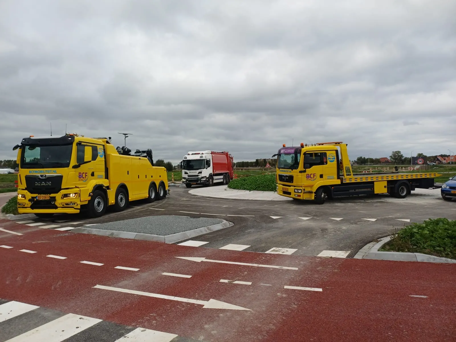 BCF Mobiliteit heavy recovery truck and flatbed truck next to a refuse truck